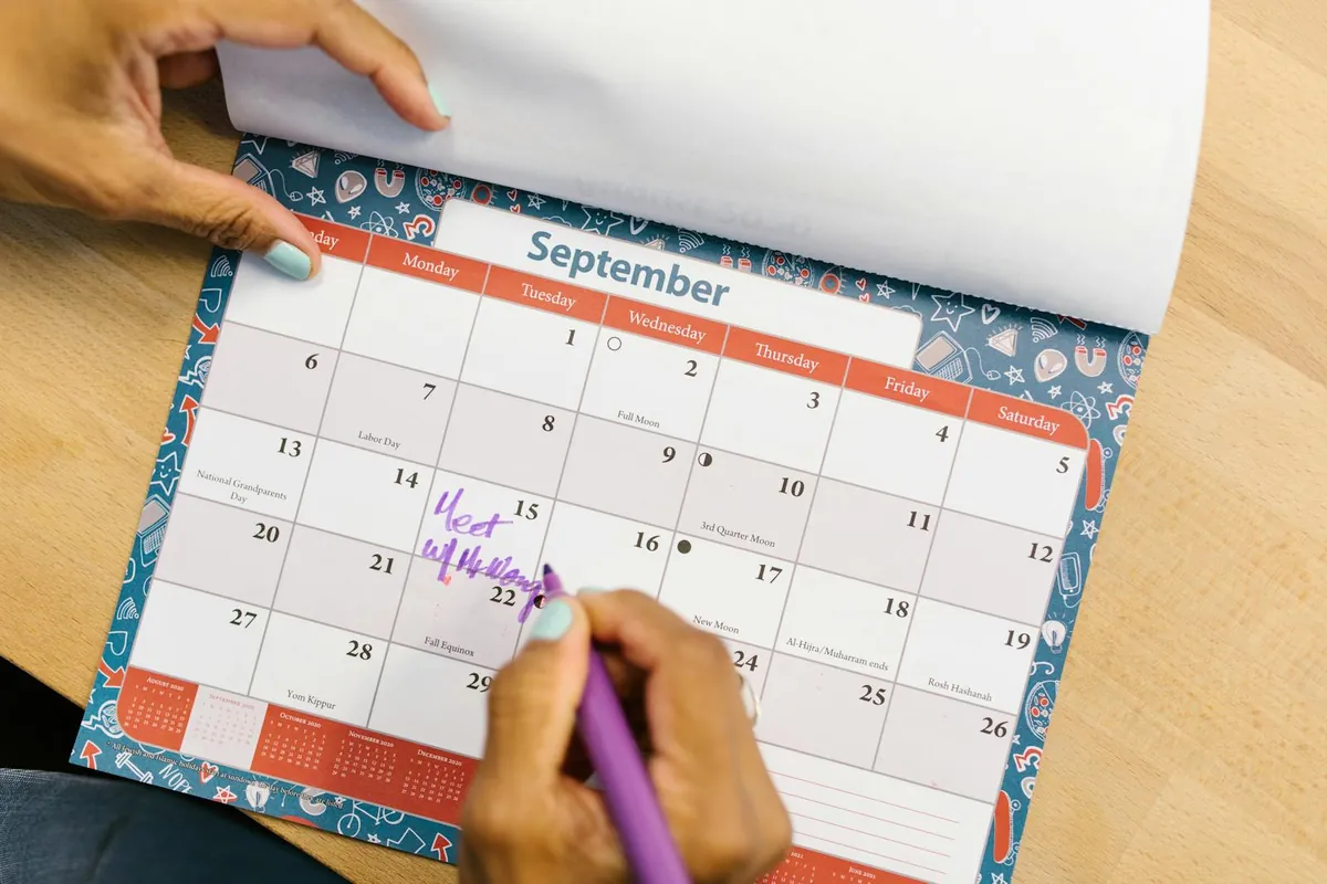 person putting tick on habit tracker calendar