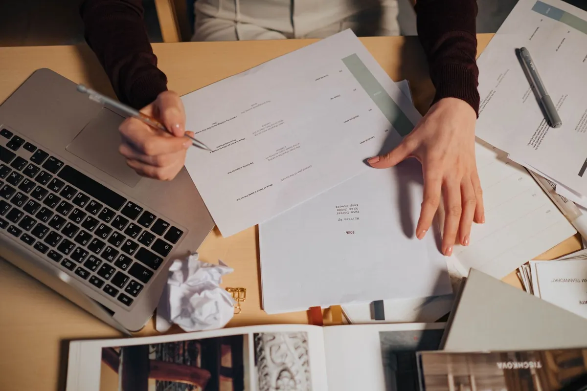 freelancer at desk laptop with proposal documents