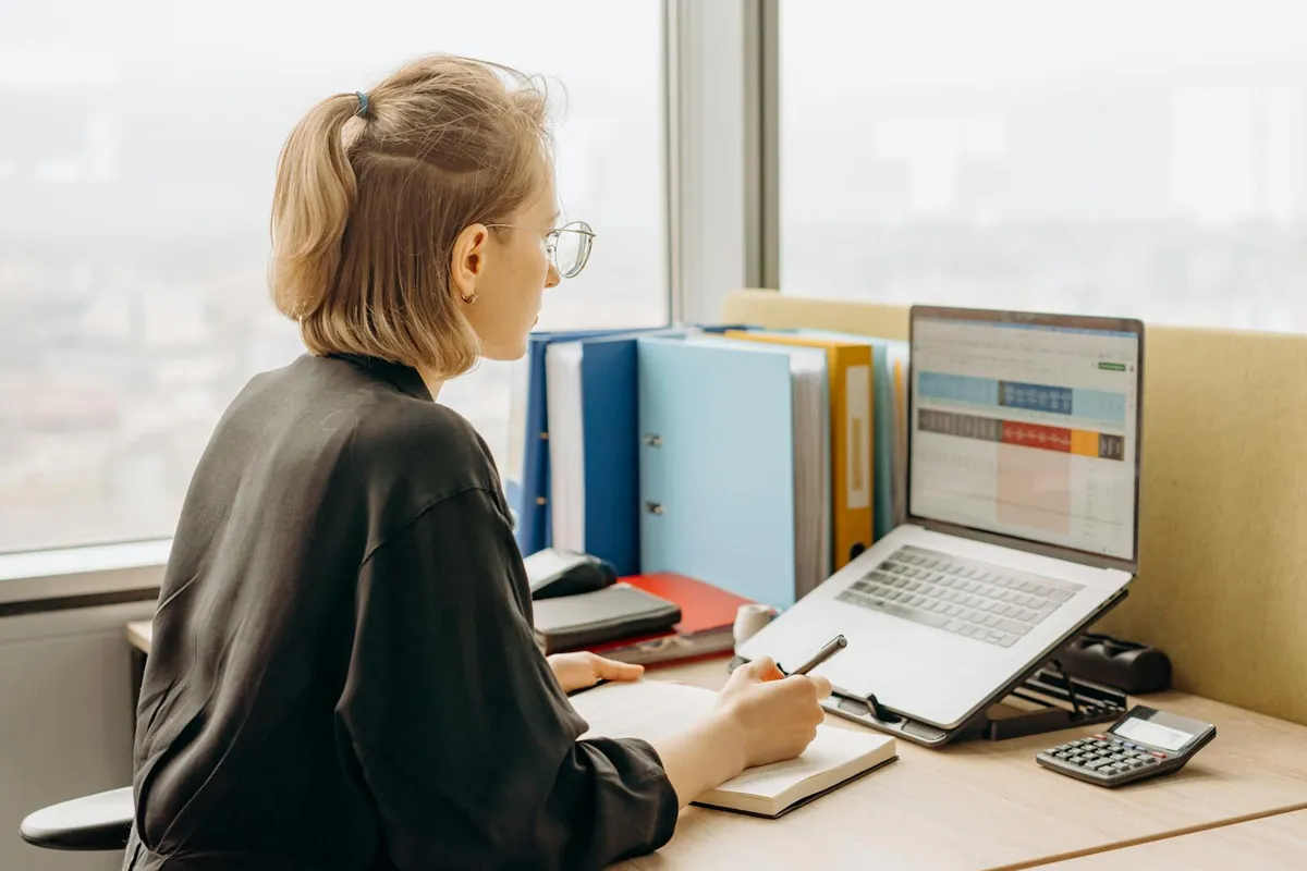 woman working at laptop reviewing salary spreadsheet