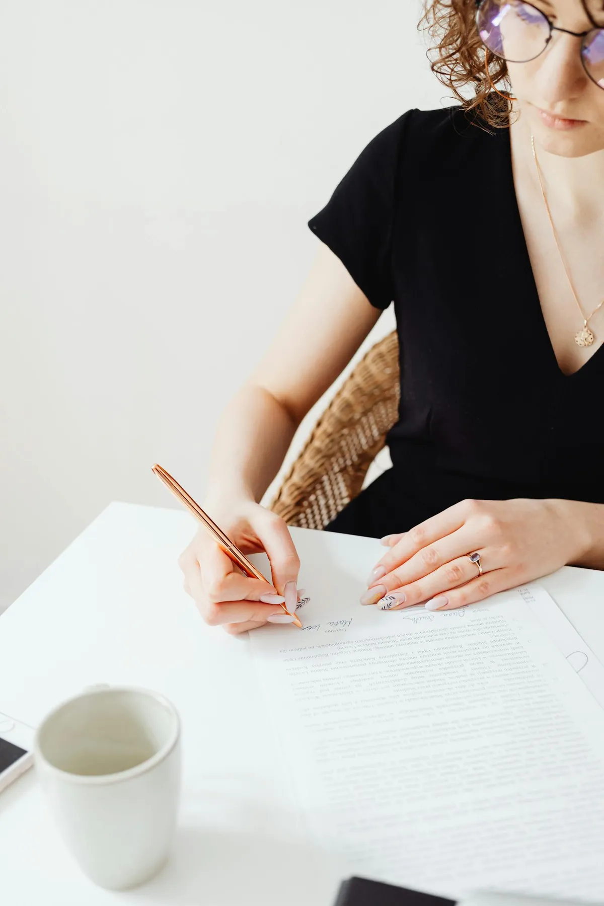 woman writing cover letter at desk with job description