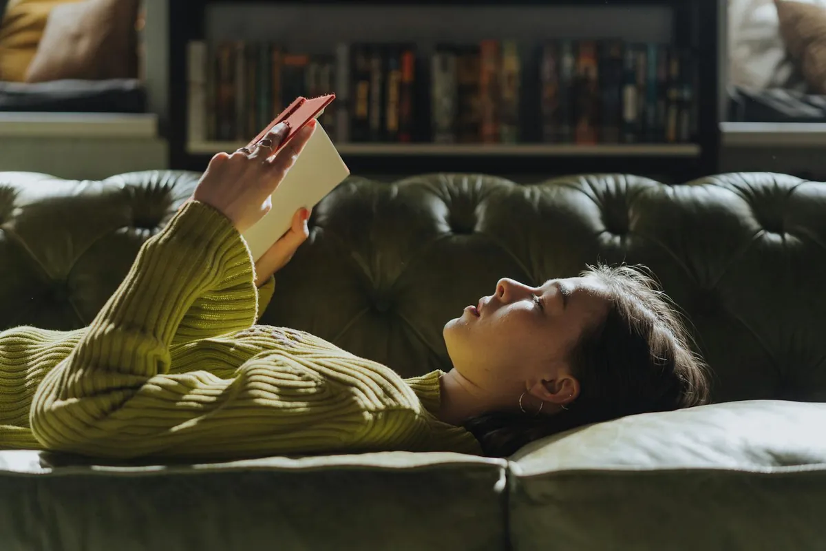 woman reading book on sofa cozy reading nook