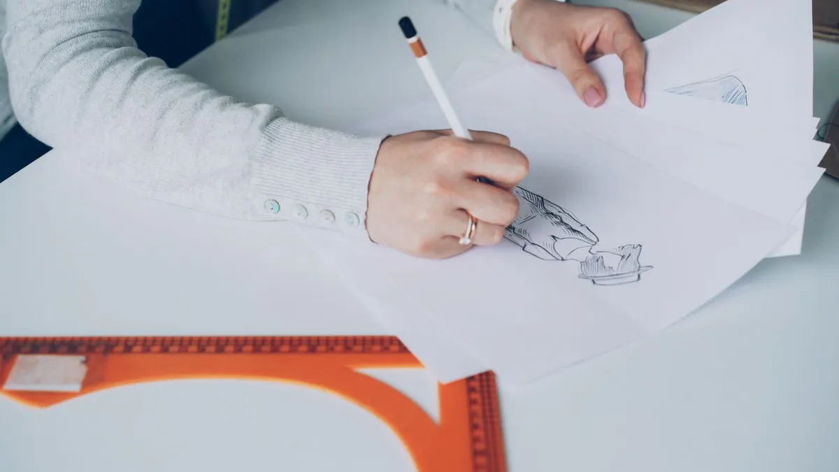 designer working on creative project at desk with sketches