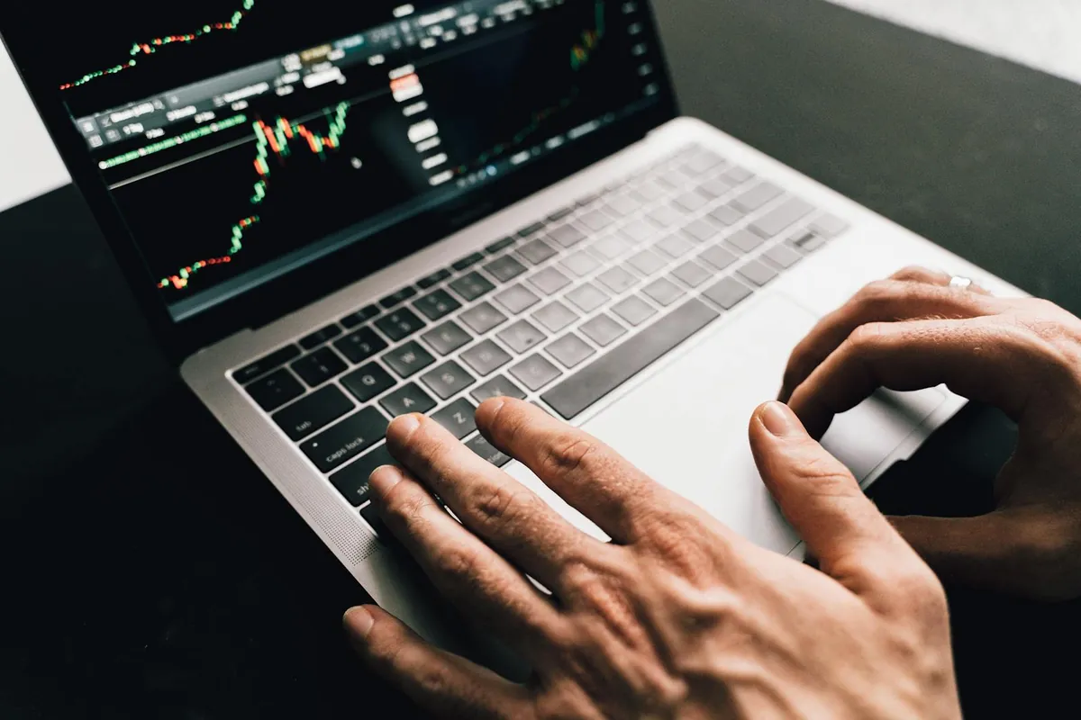 hands typing on laptop with revenue dashboard graph