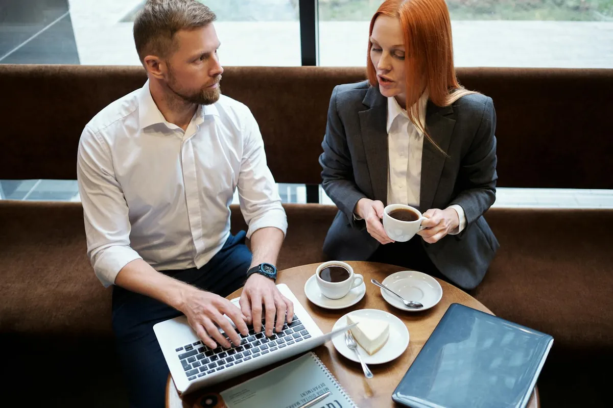 two professionals in coffee shop mentor mentee meeting