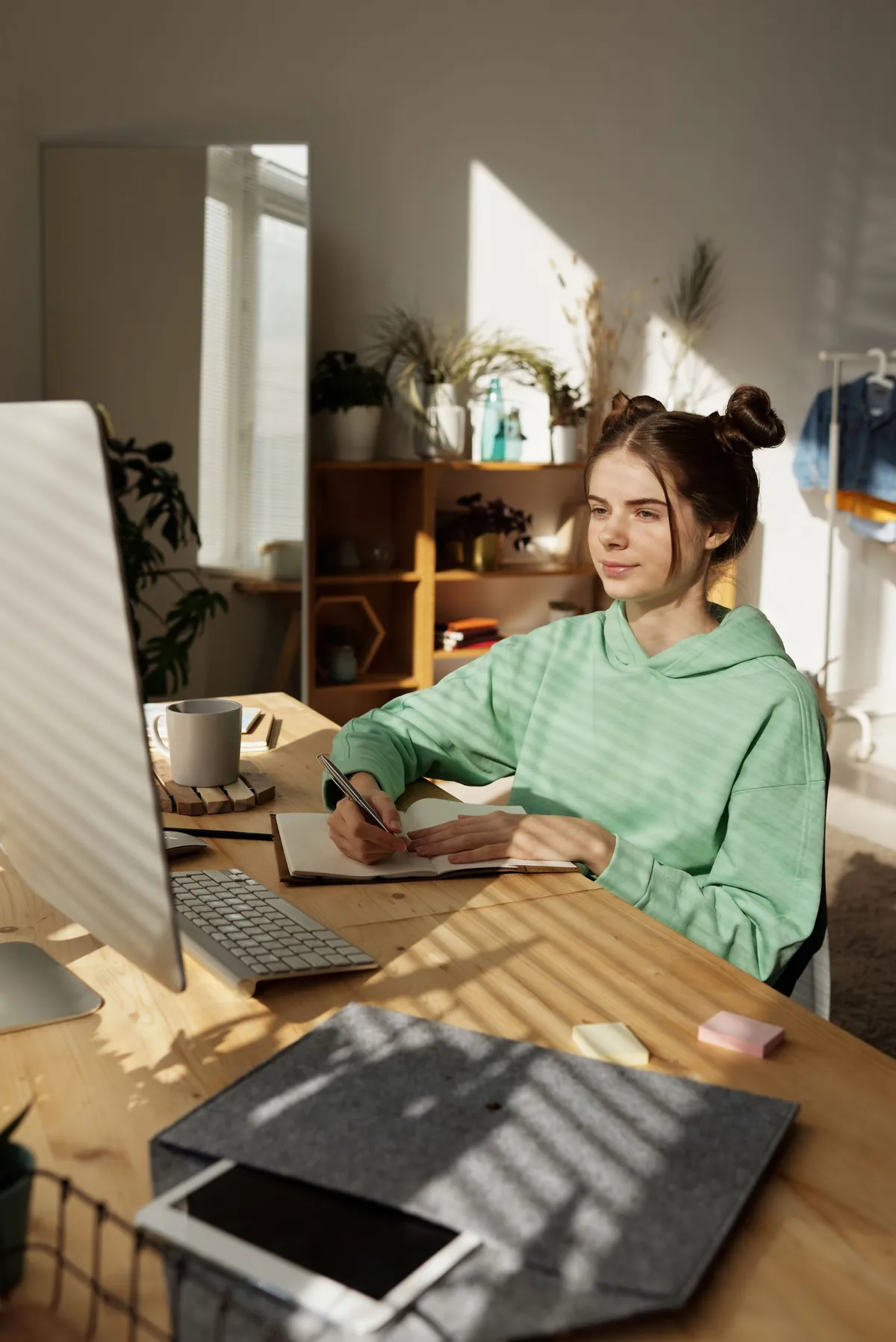 woman taking online excel course at desk with notebook